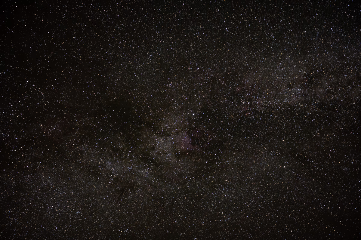 A dense starry night sky showing the dark dust lanes and bright star fields of the Milky Way galaxy.