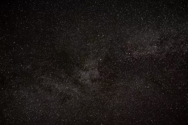 A dense starry night sky showing the dark dust lanes and bright star fields of the Milky Way galaxy.
